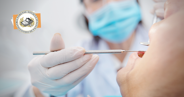 Close-up image of dentis using small mirror and carver when examining teeth of male patient.