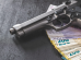 Hand gun and euro banknotes on black table.